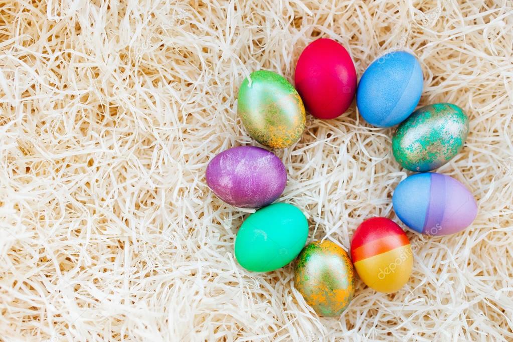 Easter multicolored eggs on the hay