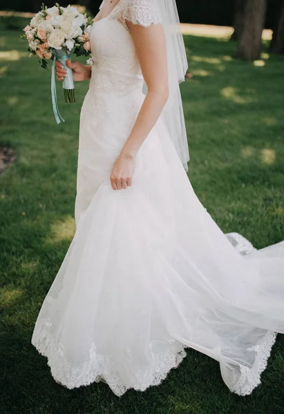 Die Braut geht in einem weißen Kleid durch den Garten — Stockfoto