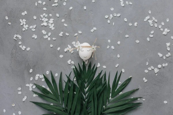 Белое Яйцо Сером Фоне Лепестками Пальмовыми Листьями — стоковое фото