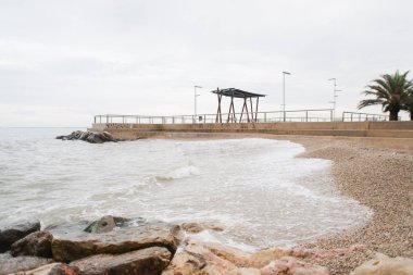 Taşlı kumsal, yağmurlu deniz.