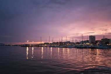 Akşam limanı, şehir ışıkları.