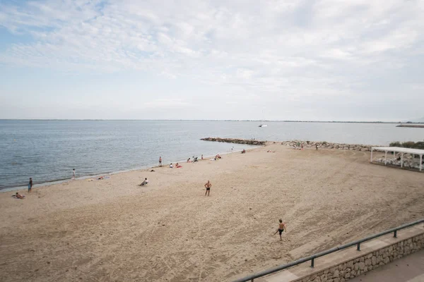 Playa con gente de arena relajante L 'Ampolla (Cataluña, España ) — Foto de Stock
