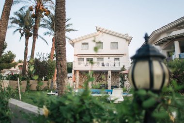 Sıcak İspanya 'da havuzu ve palmiye ağaçları olan bir villa.