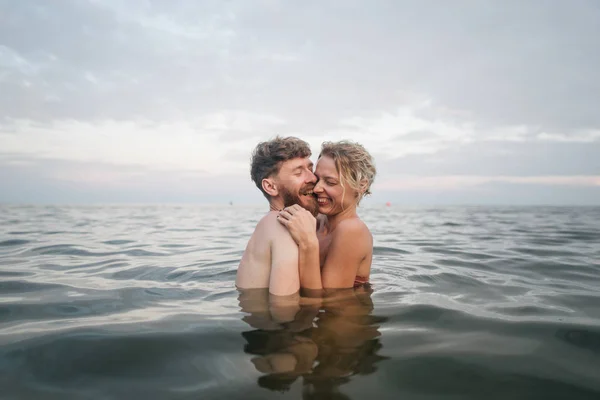 Pasangan kekasih berpelukan di laut pada liburan — Stok Foto