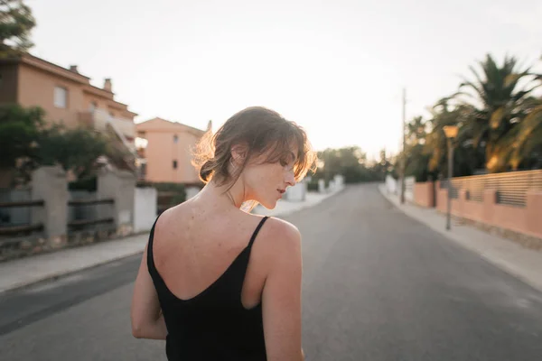 Lány sétál a város utcáin naplementekor — Stock Fotó
