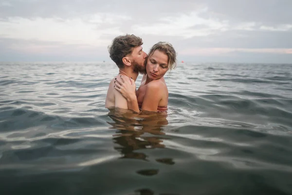 Любляча пара качається в морі у відпустці Стокове Фото