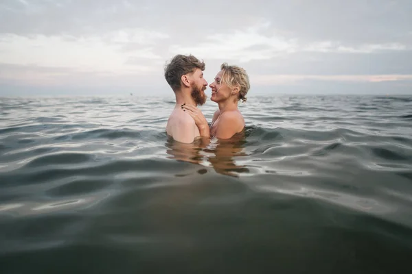Любляча пара качається в морі у відпустці Стокова Картинка
