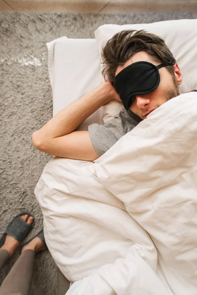 수면 마스크를 쓰고 침대에서 자고 있는 사람 — 스톡 사진