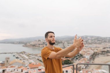 Peniscola İspanya 'nın arka planında selfie çeken genç bir adam.