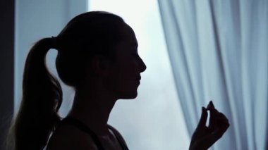 Genç kadın bir pencere bir hap almaktan