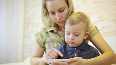 Smartphone'da oynayan anne ile erkek bebek