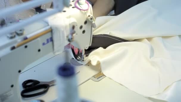 Руки жінки, коли вона керує промисловою швейною машиною — стокове відео