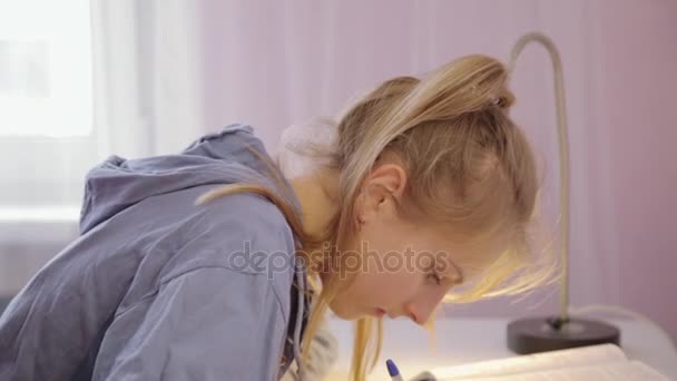 Teen flicka gör hennes läxor drar en penna — Stockvideo