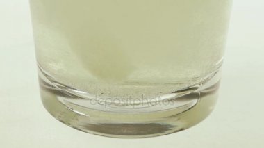Çözünen vitamin C bir tablet bir bardak su düşmek.