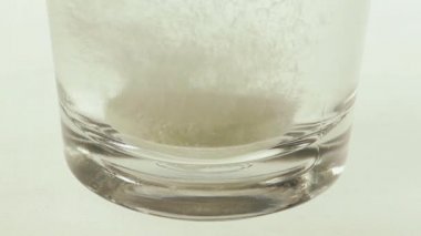 Çözünen vitamin C bir tablet bir bardak su düşmek.