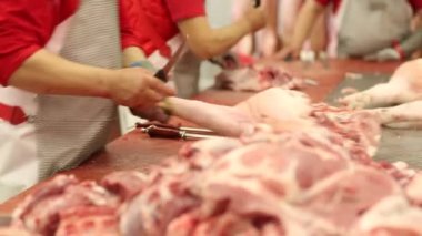 Domuz leşleri özel bir masada bıçak ile kesme.