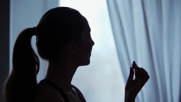 妇女吞咽补充药丸对窗口 — 图库视频影像