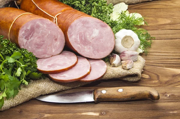 Pork sausage sliced in small pieces in a white packing on wooden — Stock Photo, Image