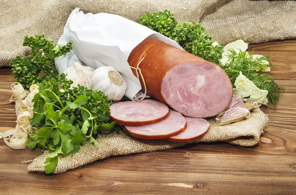 Pork sausage sliced in small pieces in a white packing on wooden — Stock Photo, Image