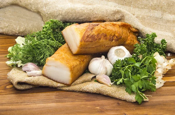 Smoked lard sliced in pieces on wooden table — Stock Photo, Image