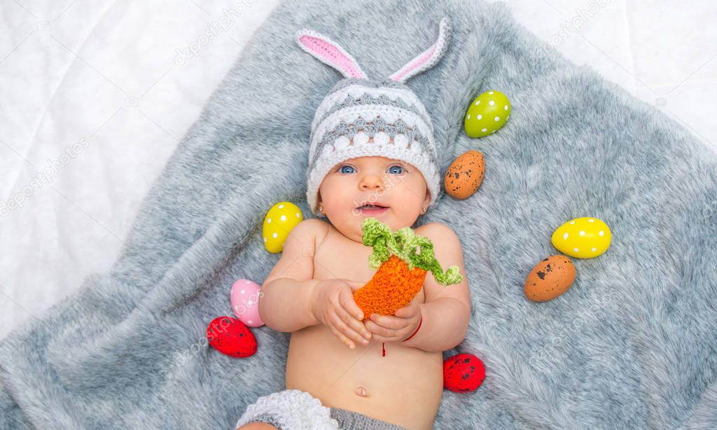 Cheerful baby girl in bunny hat gray blanket 