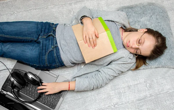 Chica adolescente durmiendo en el suelo con un libro en sus manos —  Fotos de Stock