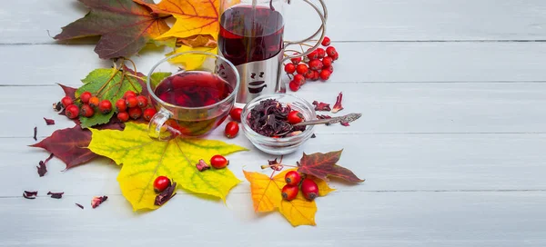 Xícara de chá de frutas e chaleira ainda vida em folhas de outono — Fotografia de Stock