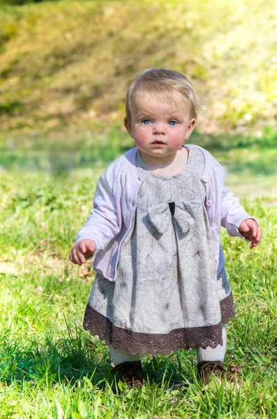 Little baby girl stands in the park — Stock Photo, Image