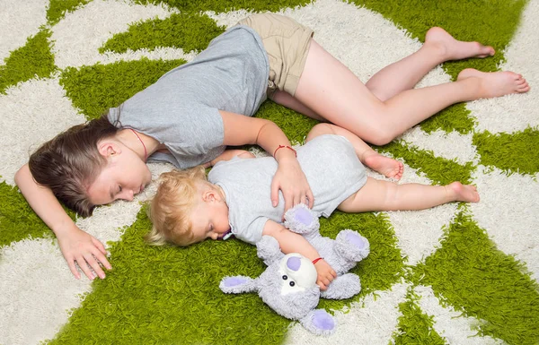 Moe twee meisjes zus viel in slaap op het tapijt — Stockfoto