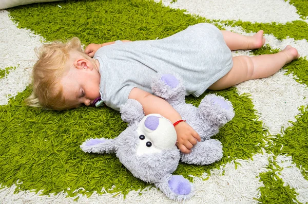 Meisje is slapen op het tapijt — Stockfoto