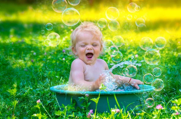 Linda niña bebé divirtiéndose con agua . Imagen De Stock