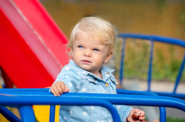 Porträt eines blonden Mädchens mit blauen Augen auf einem Spielplatz — Stockfoto