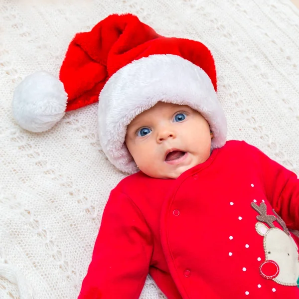 小女婴在圣诞老人的帽子，她看着相机. — 图库照片