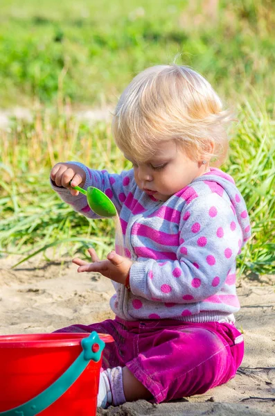 Babymeisje spelen in het zand. — Stockfoto