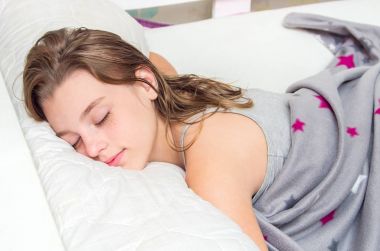 Güzel genç kız yatakta uyuyor. Portre.