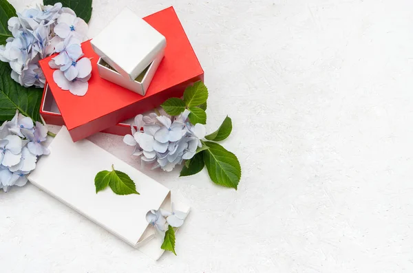 Les boîtes-cadeaux sont de couleur blanche et rouge avec des fleurs d'hortensia — Photo