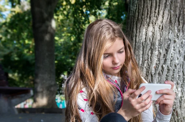 Young happy teenager girl using smart phone — Stock Photo, Image