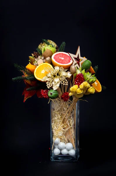 composition bouquet of fruits in a vase on a black background.