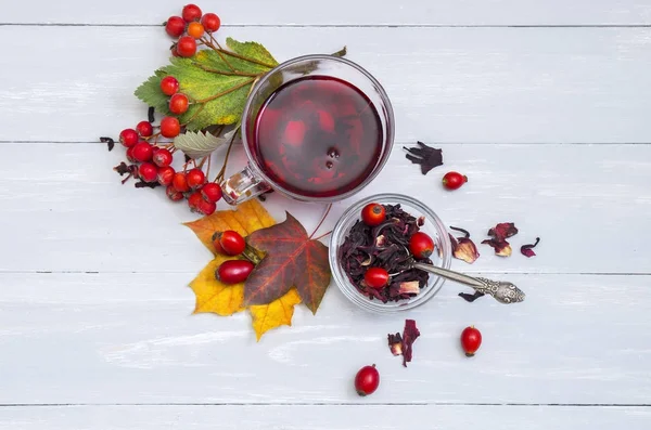 Still life cup of fruit tea on autumn leaves and vintage wood — Stock Photo, Image