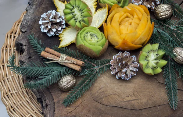 Složení čerstvého vyřezávané ovoce zdobené s větvemi jedlí — Stock fotografie