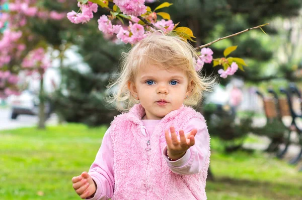 Little charming blonde playing with pleasure in the garden — Stock Photo, Image