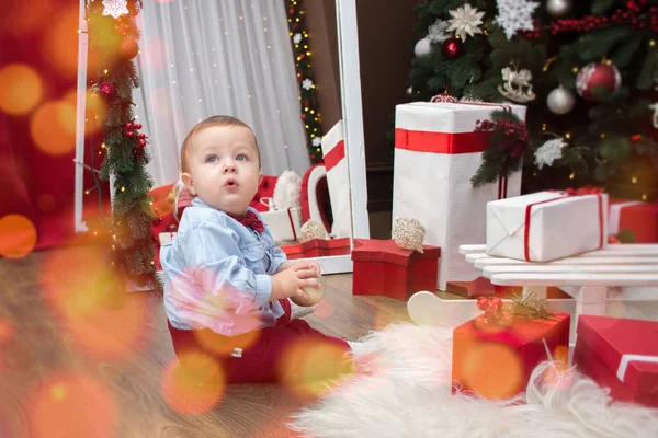 Băiatul se joacă cu cadouri într-o cameră decorată — Fotografie, imagine de stoc