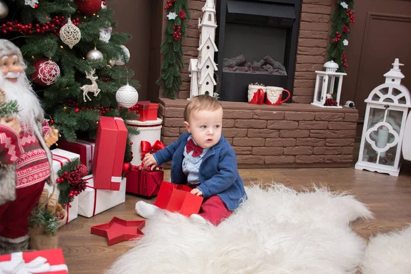 Băiatul se joacă cu cadouri într-o cameră decorată — Fotografie, imagine de stoc