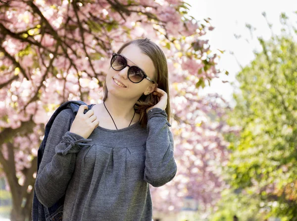 Retrato de una linda chica adolescente con gafas contra el fondo — Foto de Stock