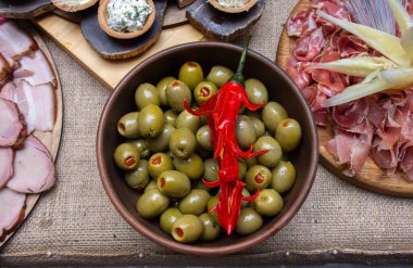 Doldurulmuş yeşil zeytinli ve acı biberli tabak. Acı biberle süslenmiş. Eti dilimliyor.