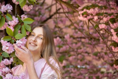 Narin sakura çiçekleri içinde güzel bir genç kızın portresi.