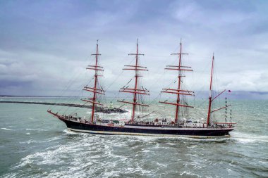 IJmuiden, Hollanda - 18 Ağustos 2015: Uzun gemi geçen deniz feneri yağmur fırtınada