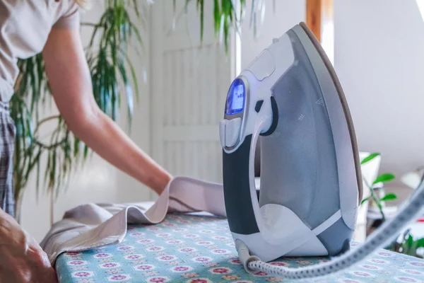 Primer plano de la mujer planchando la ropa en la tabla de planchar — Foto de Stock