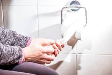 A yakın çekim ladys el kullanarak tuvalet kağıdı