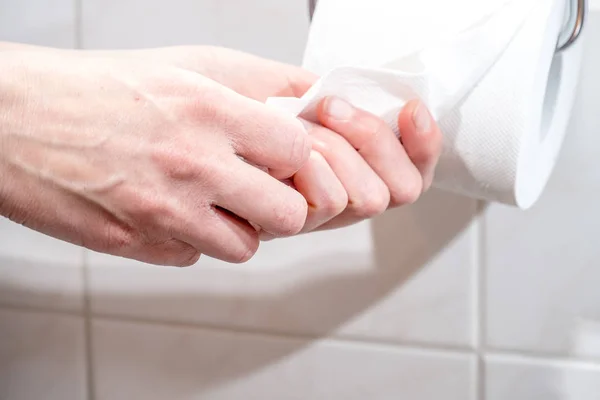 A yakın çekim ladys el kullanarak tuvalet kağıdı